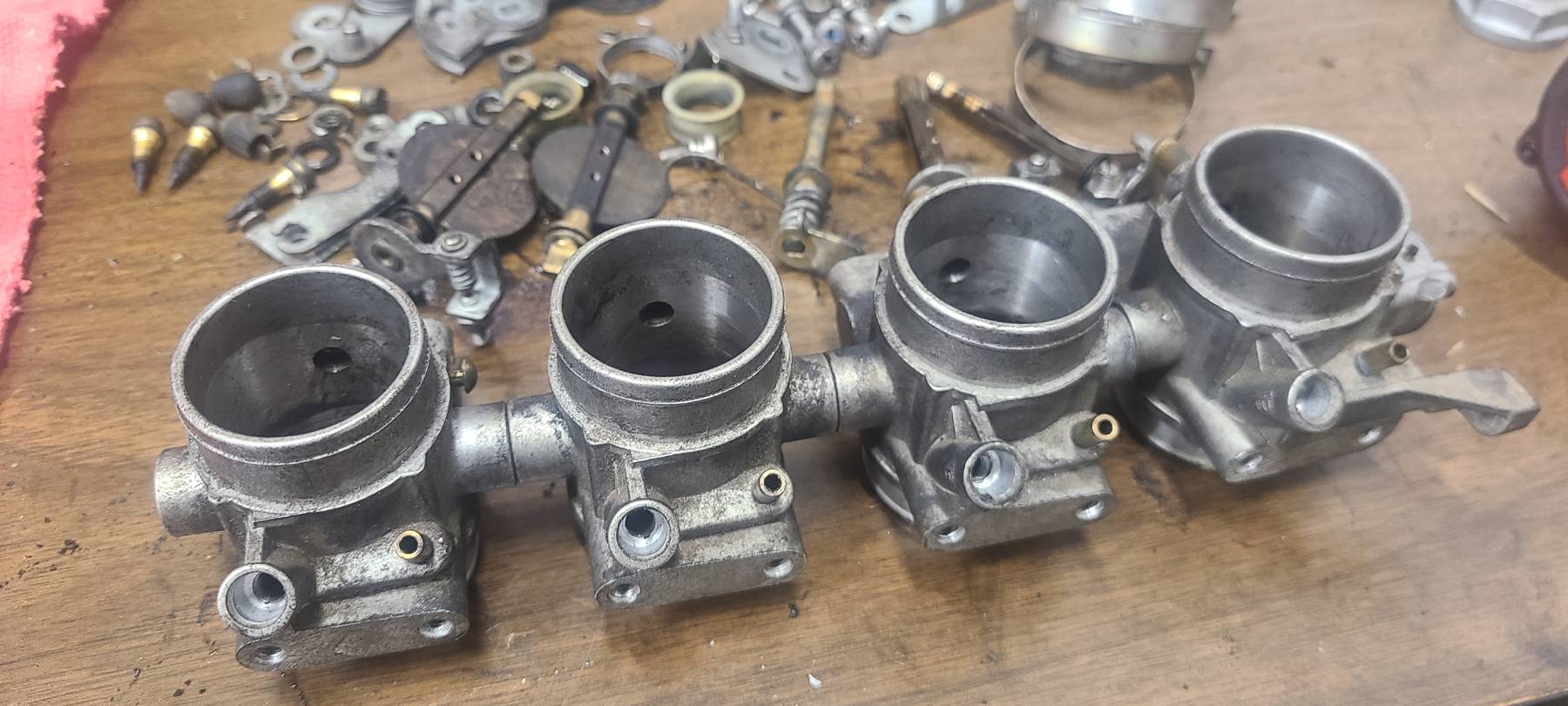 Old K1100 throttle body assembly partially disassembled on a workbench
